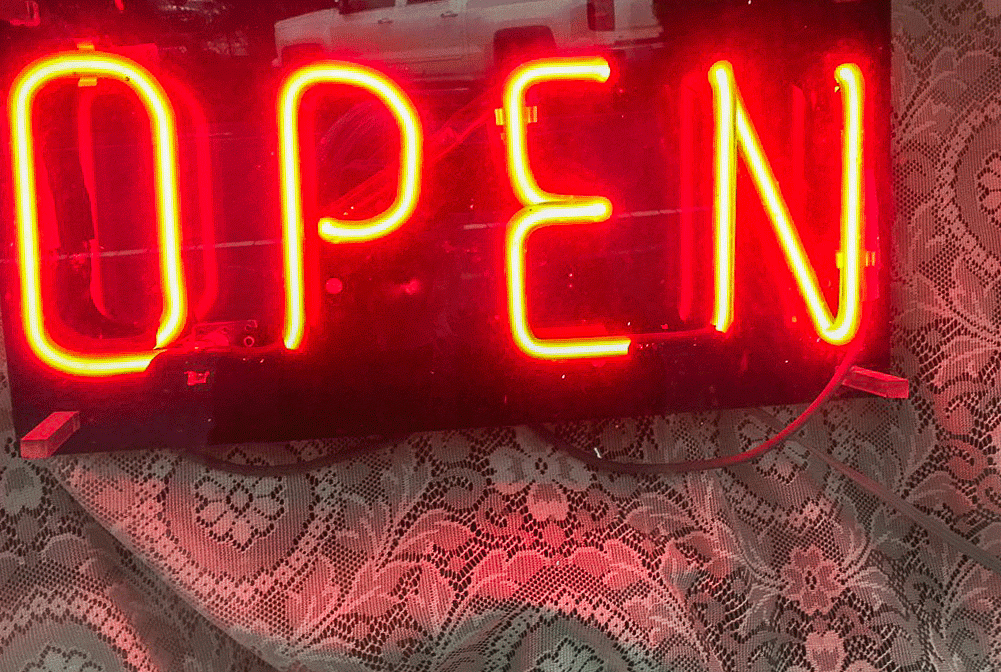 red neon light up sign that says open
